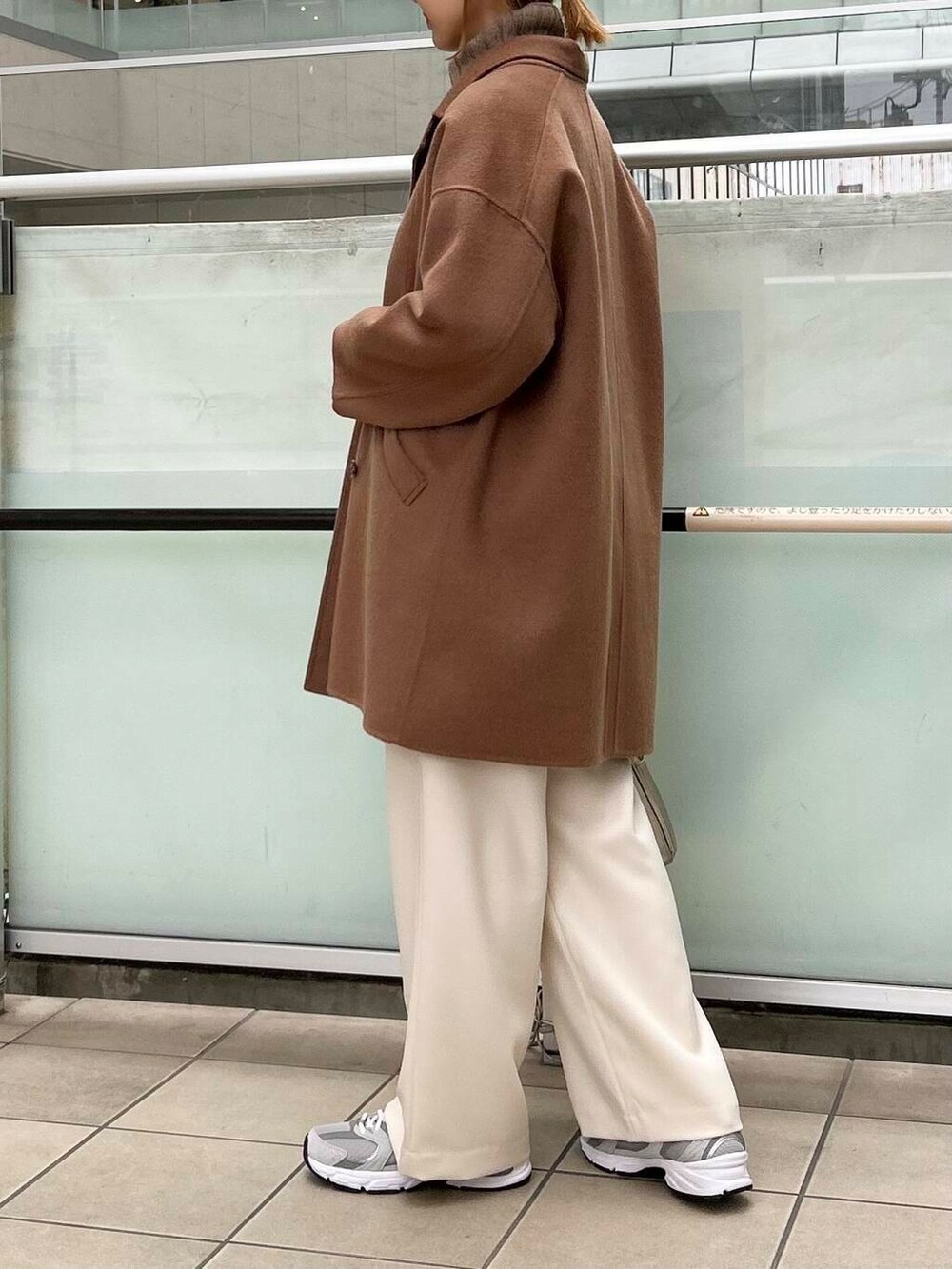 ブラウン系のその他アウター、ゴールド系のショルダーバッグ、ホワイト系のニット/セーターを着用したレディースの秋コーディネートの3枚目の写真