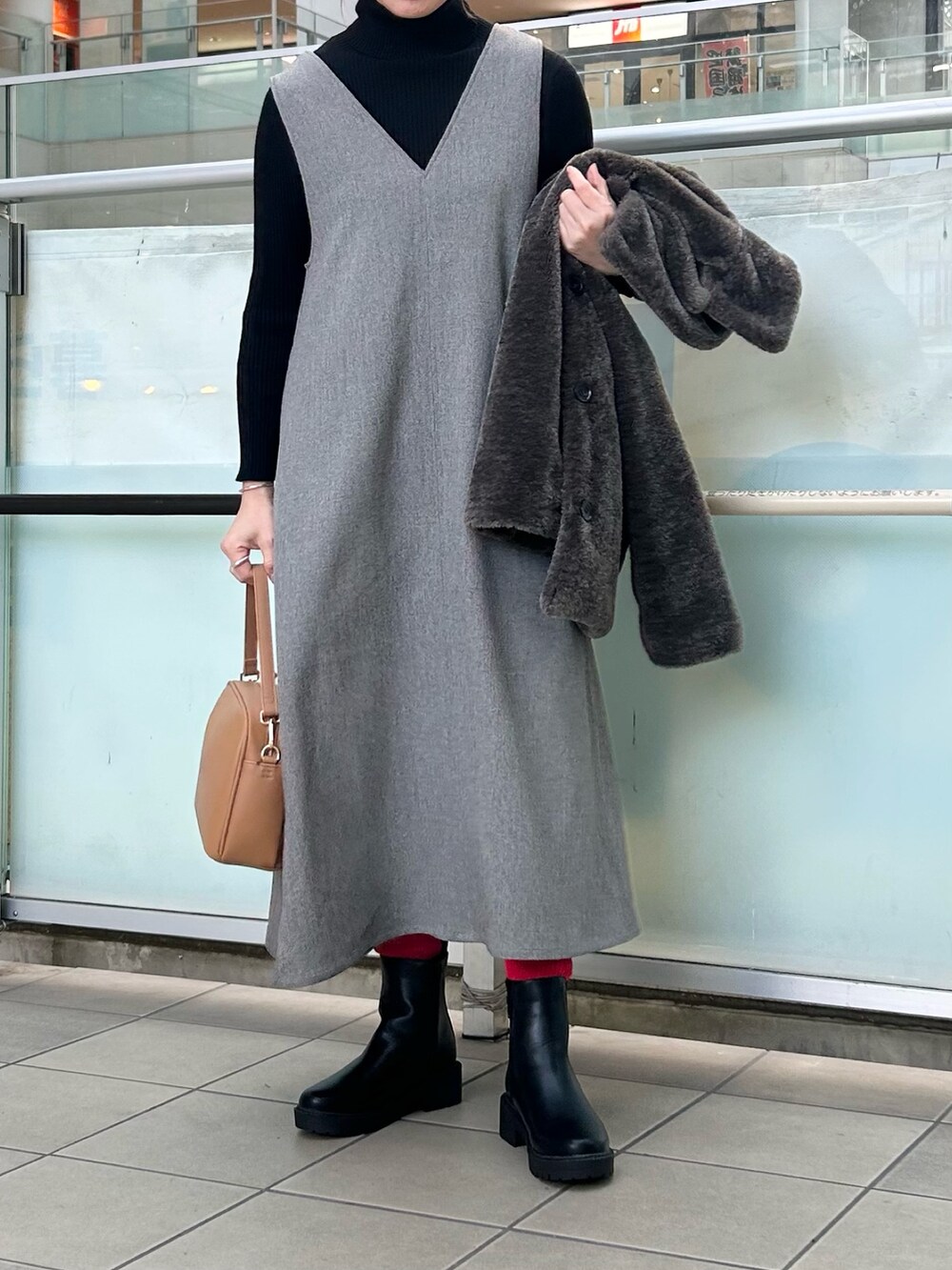 グレー系のその他アウター、グレー系のワンピース、ベージュ系のショルダーバッグを着用したレディースの冬コーディネートの4枚目の写真