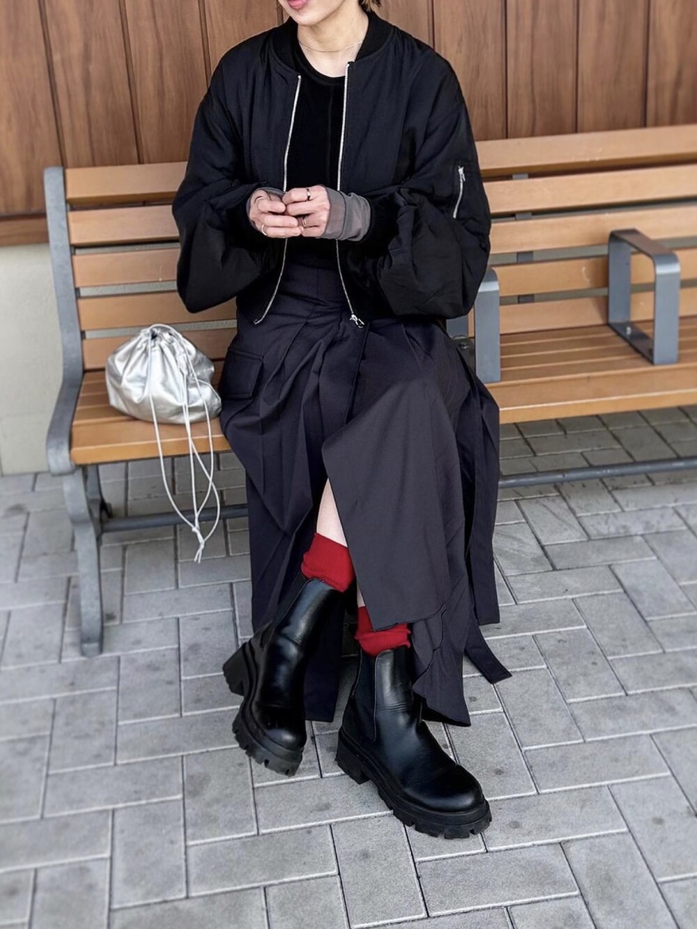 ブラック系のTシャツ/カットソー、グレー系のスカート、ブラック系のブーツを着用したレディースの冬コーディネートの3枚目の写真