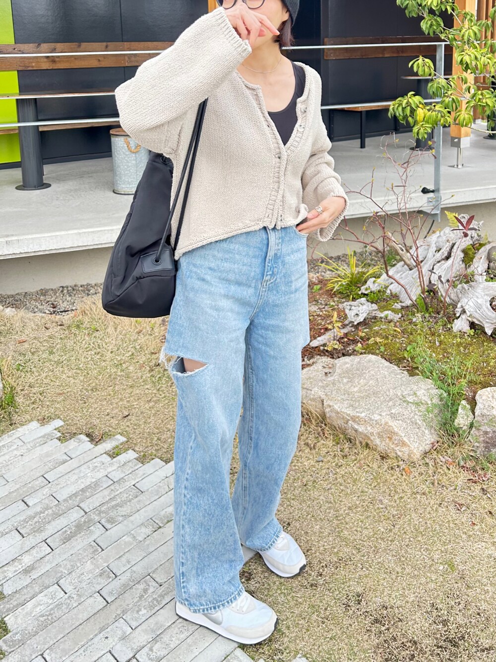 ブルー系のデニムパンツ、シルバー系のスニーカー、ブラック系のバックパック/リュックを着用したレディースの春コーディネートの2枚目の写真