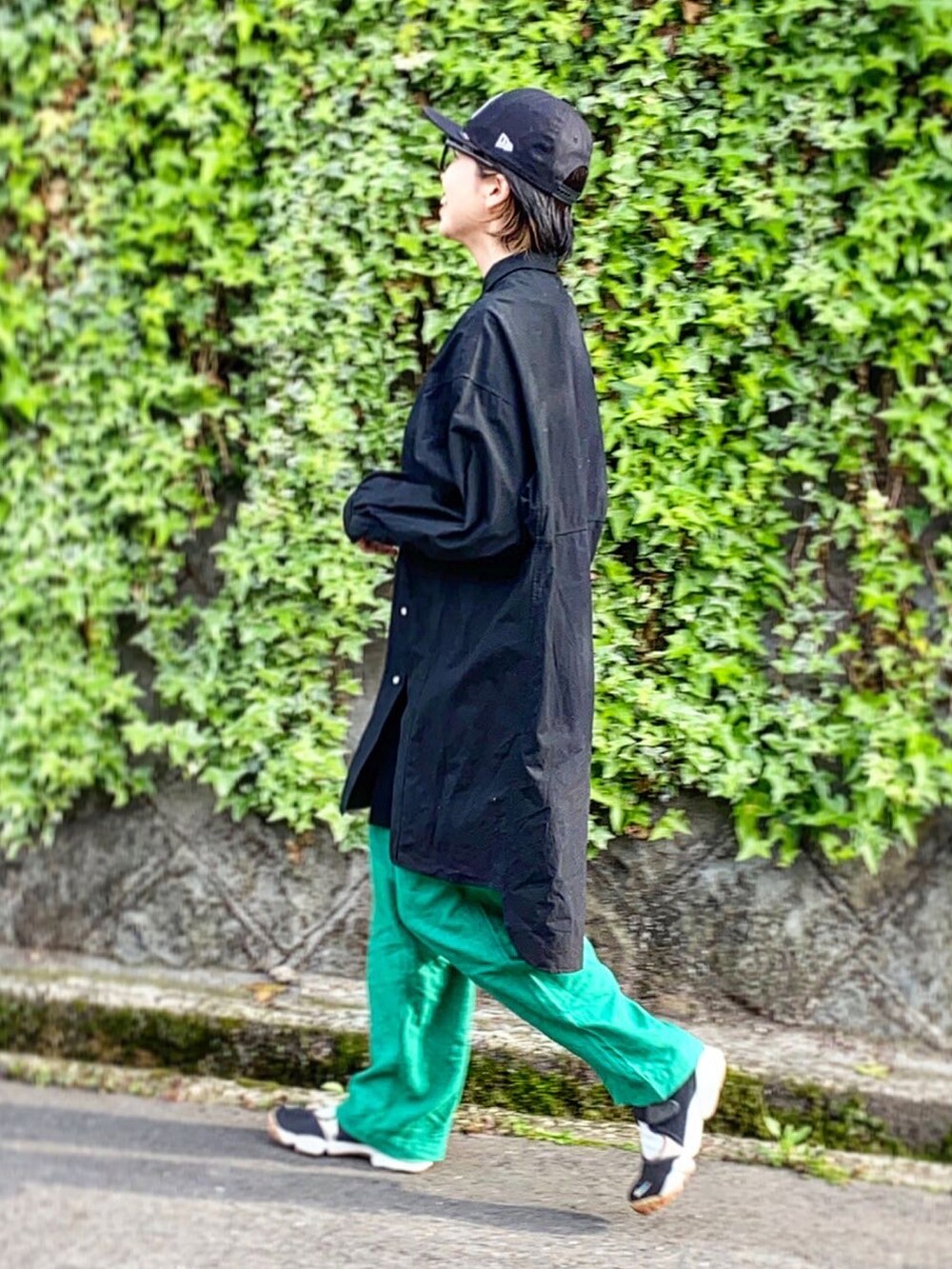 グリーン系のその他パンツ、ブラック系のスニーカー、ブラック系のキャップを着用したレディースの春コーディネートの2枚目の写真
