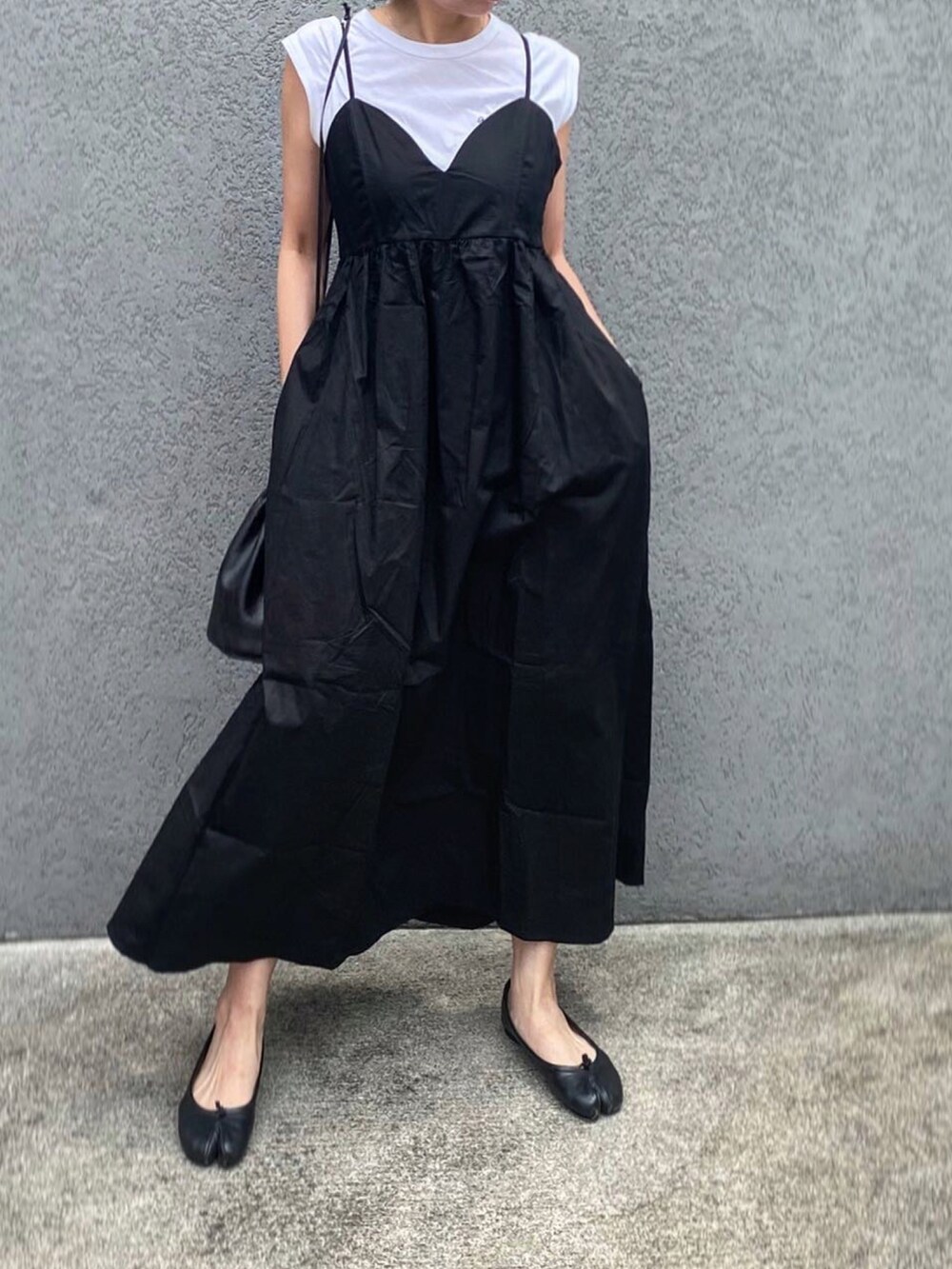 ブラック系のバレエシューズ、ブラック系のワンピース/ドレス、ホワイト系のTシャツ/カットソーを着用したレディースの夏コーディネートの2枚目の写真