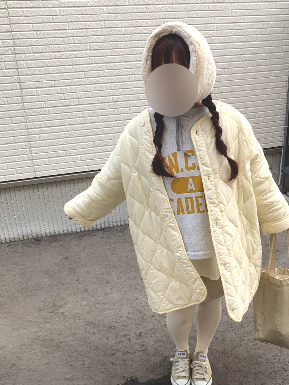 ホワイト系のミリタリージャケット、ホワイト系のスウェット、ゴールド系のスカートを着用したレディースの冬コーディネートの2枚目の写真