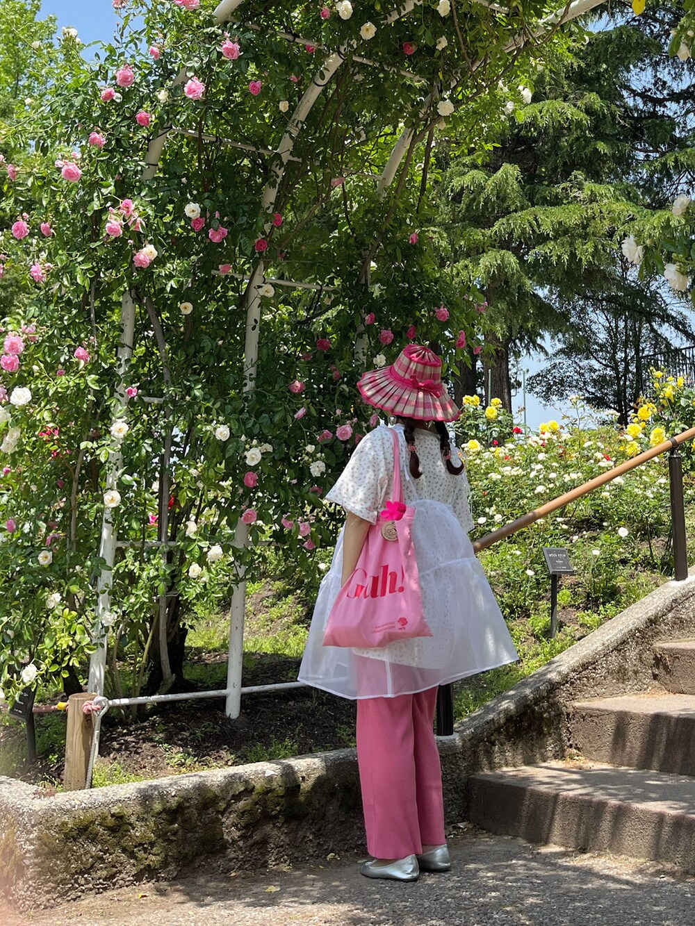 ピンク系のトートバッグ、ピンク系のTシャツ/カットソー、ホワイト系のワンピースを着用したレディースの春コーディネートの2枚目の写真