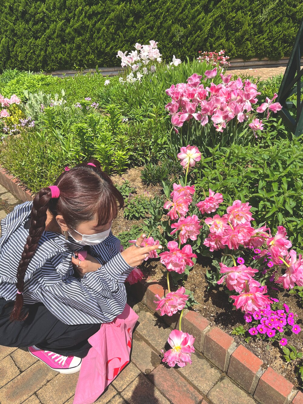 ブラック系のシャツ/ブラウス、ブラック系のサロペット/オーバーオール、ピンク系のスニーカーを着用したレディースの春コーディネートの2枚目の写真