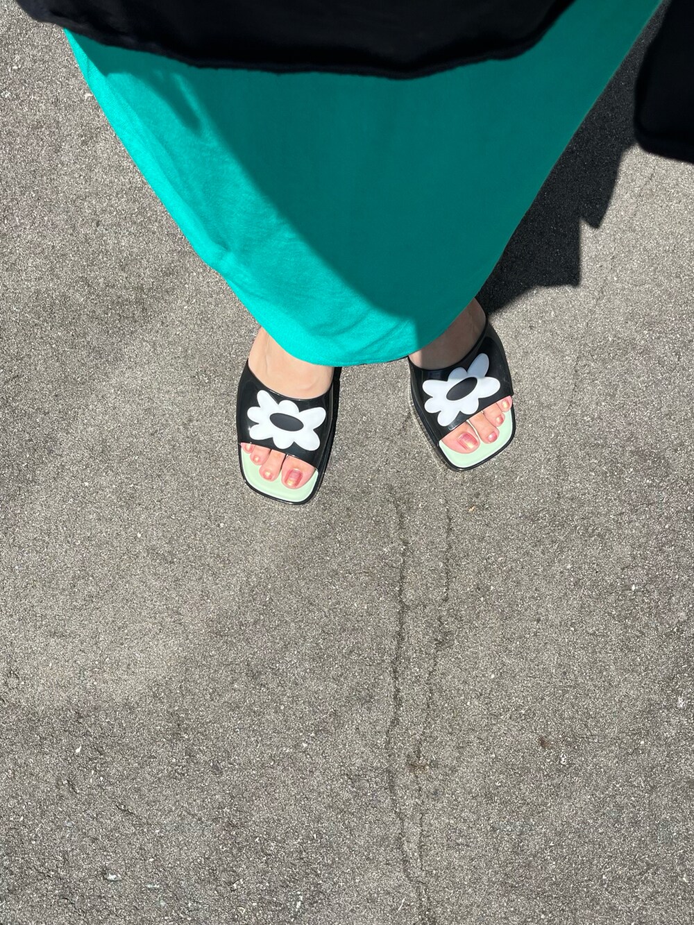 ブラック系のサンダル、グリーン系のスカート、グリーン系のトートバッグを着用したレディースの夏コーディネートの2枚目の写真