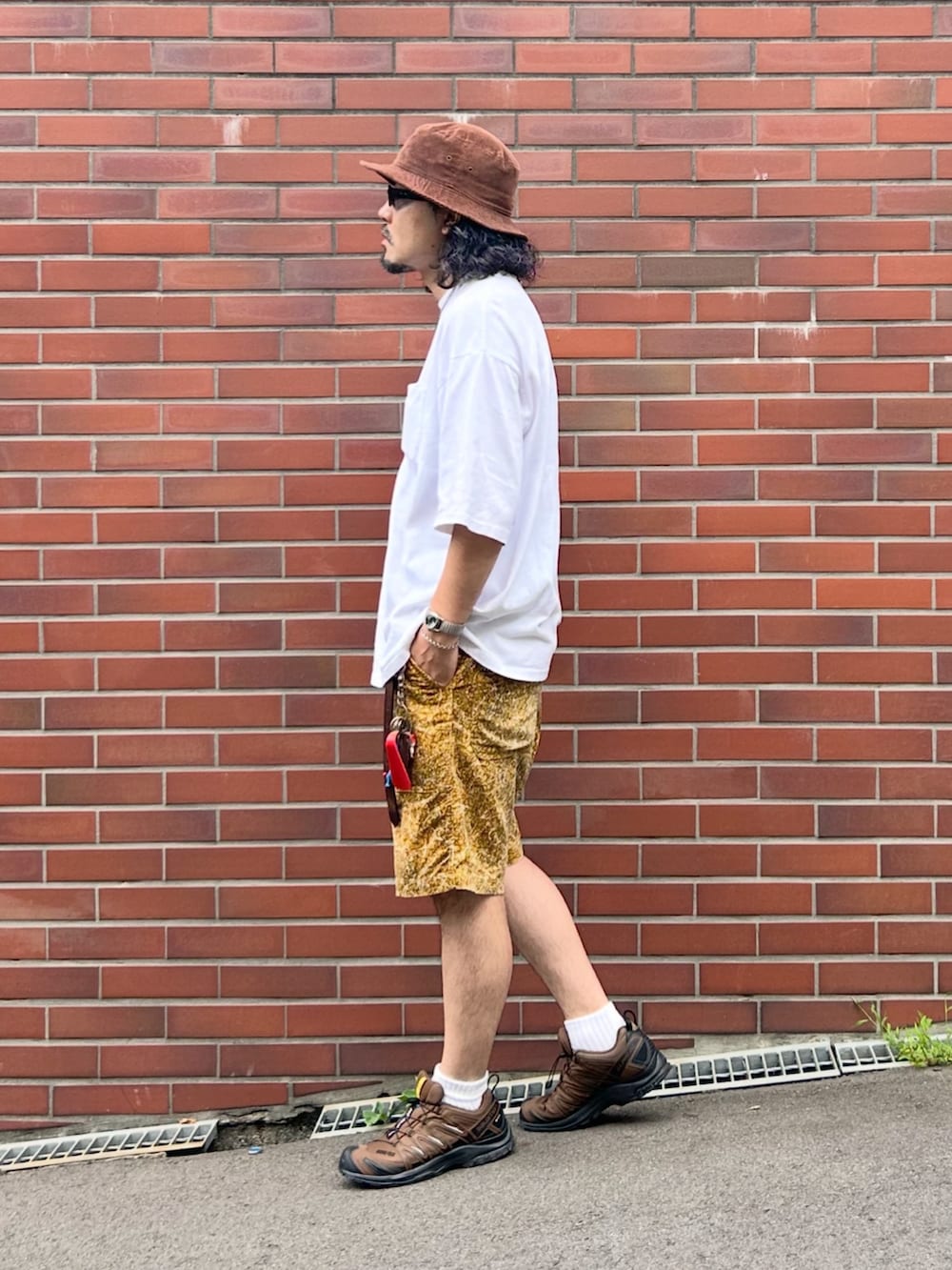 グレー系のタンクトップ、ホワイト系のTシャツ/カットソー、ブラウン系のスニーカーを着用したメンズの秋コーディネートの2枚目の写真