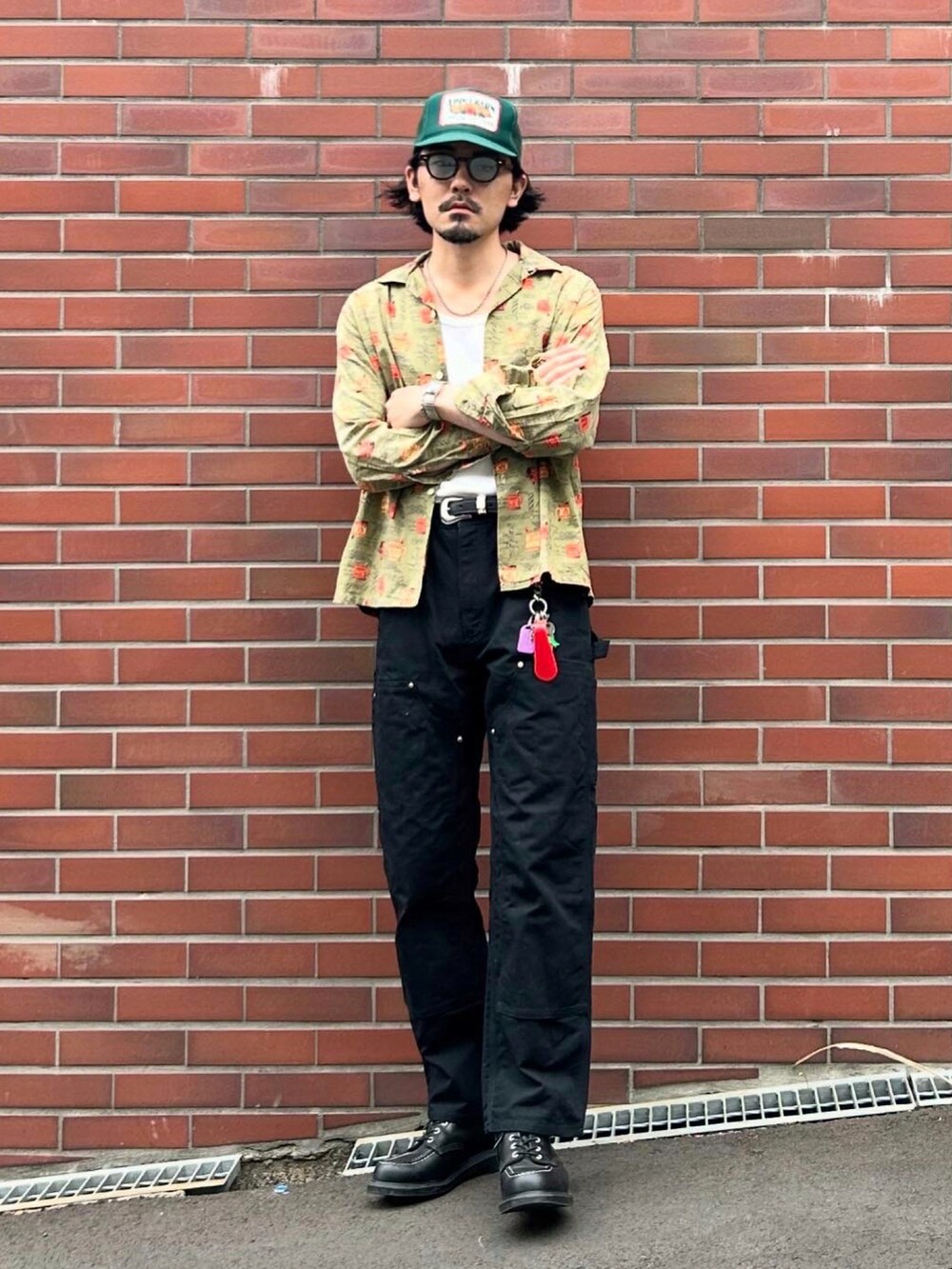 グリーン系のシャツ/ブラウス、ホワイト系のタンクトップ、ブラック系のチノパンツを着用したメンズの春コーディネートの2枚目の写真