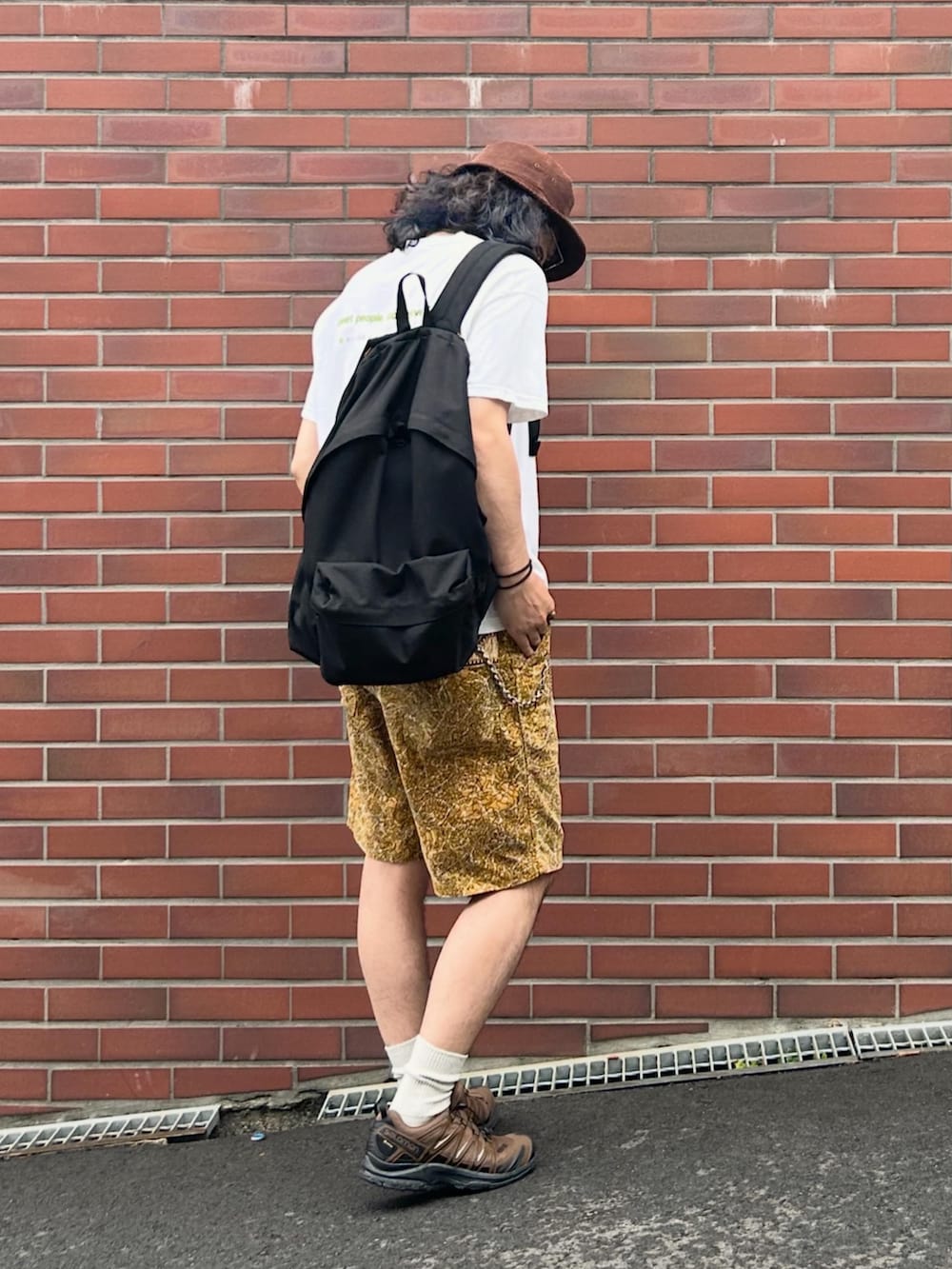 ブラウン系のスニーカー、ホワイト系のTシャツ/カットソー、イエロー系のパンツを着用したメンズの夏コーディネートの3枚目の写真