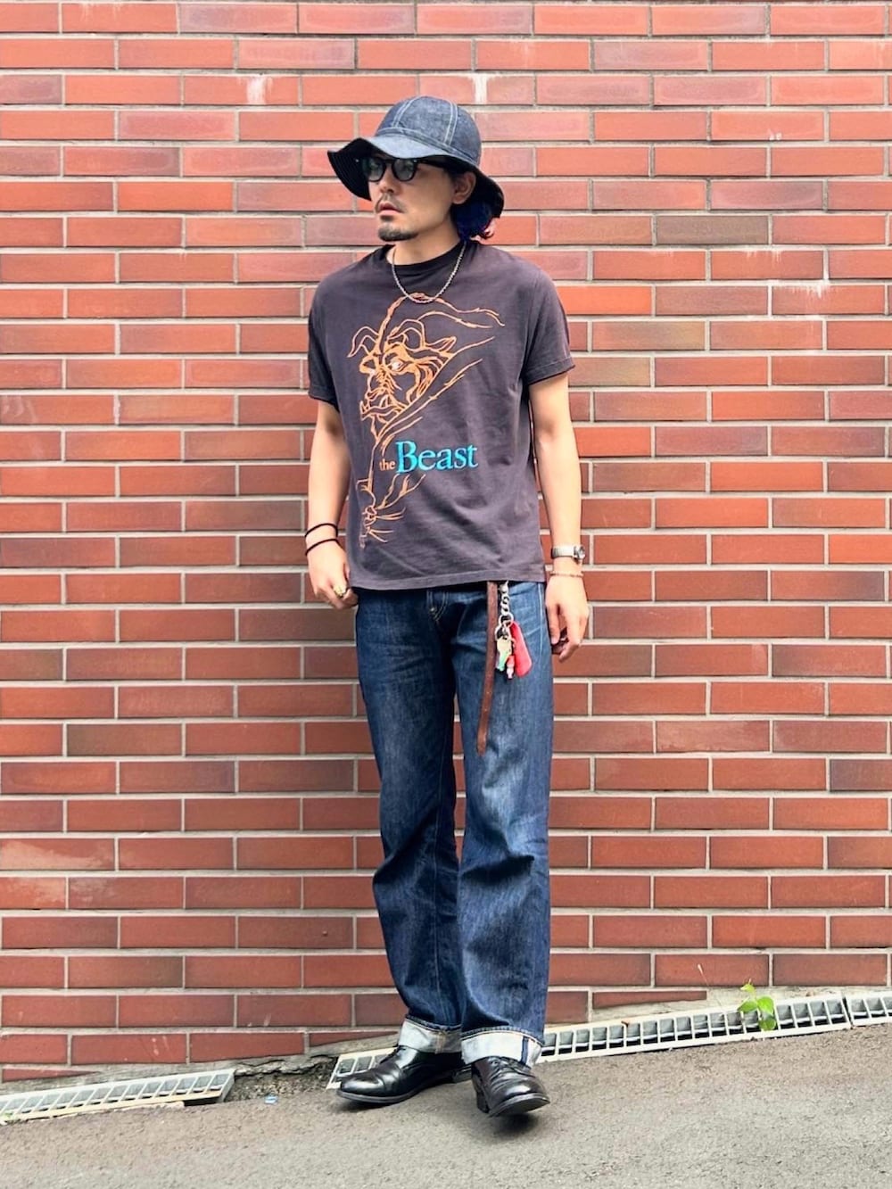 ブルー系のデニムパンツ、ブラック系のTシャツ/カットソー、ブラック系のドレスシューズを着用したメンズの夏コーディネートの2枚目の写真