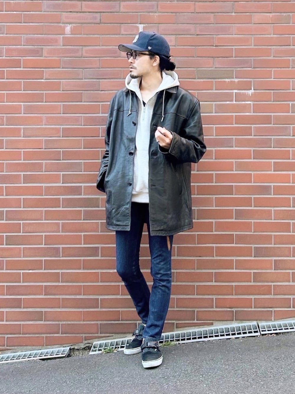 ブラック系のステンカラーコート、グレー系のパーカー、ブラック系のTシャツ/カットソーを着用したメンズの秋コーディネートの2枚目の写真