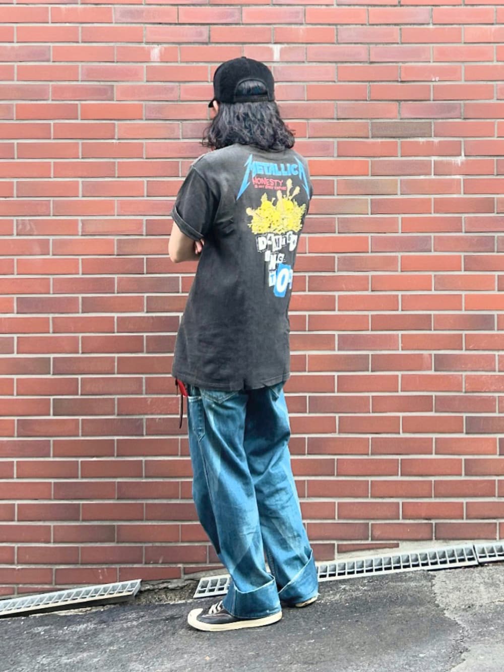 ブラック系のTシャツ/カットソー、ブルー系のデニムパンツ、ブラック系のスニーカーを着用したメンズの夏コーディネートの2枚目の写真