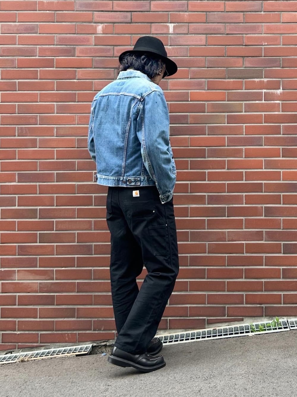 ブラック系のチノパンツ、ブラック系のブーツ、ホワイト系のタンクトップを着用したメンズの秋コーディネートの3枚目の写真