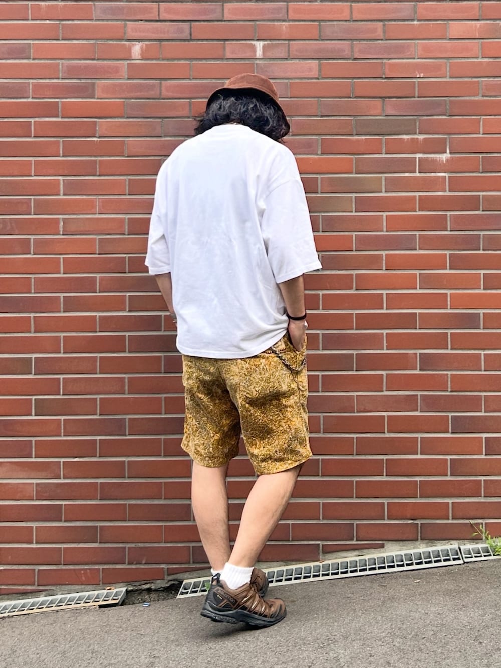 グレー系のタンクトップ、ホワイト系のTシャツ/カットソー、ブラウン系のスニーカーを着用したメンズの秋コーディネートの3枚目の写真