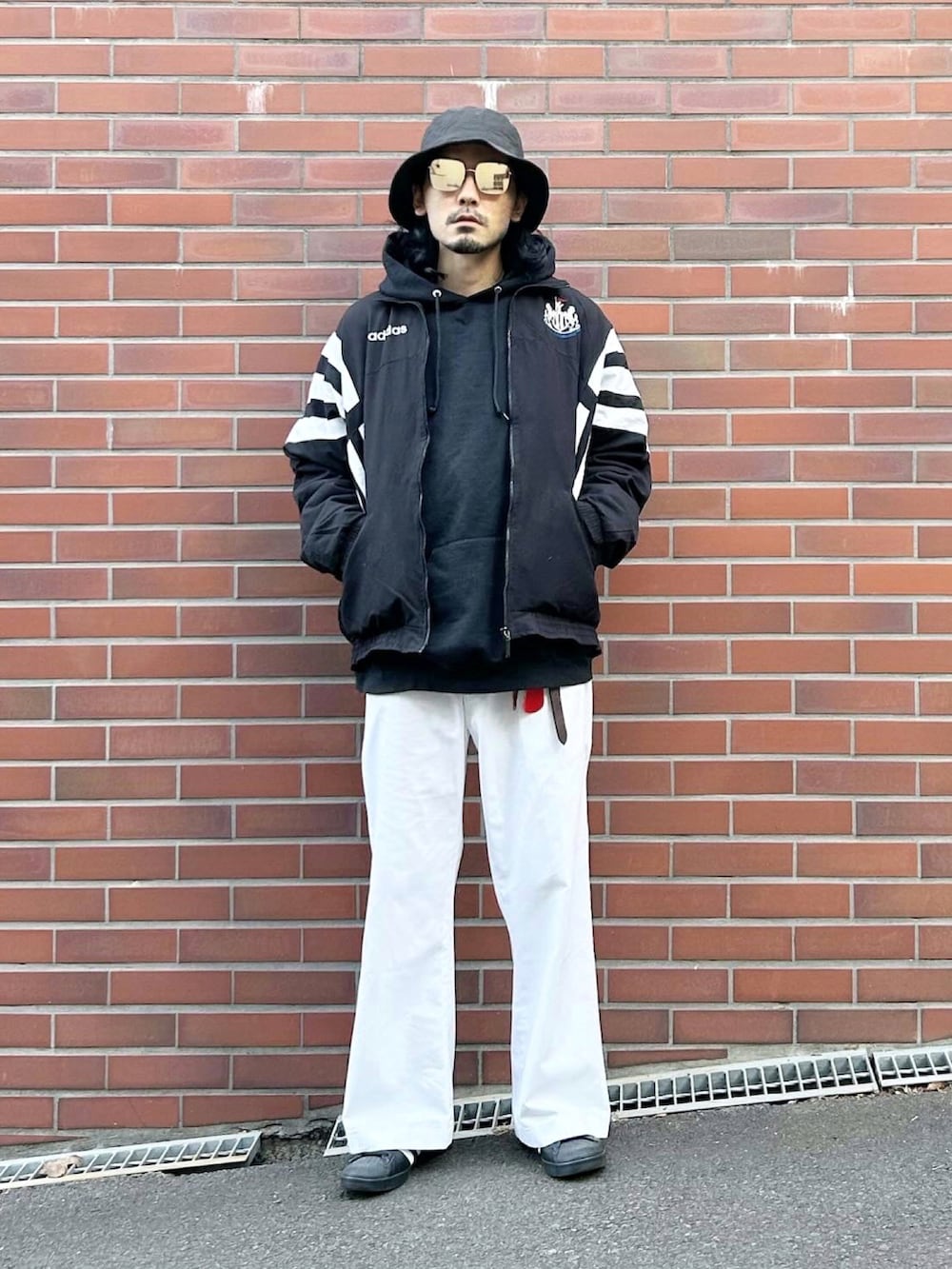 ブラック系のナイロンジャケット、ブラック系のパーカー、ブラック系のその他アウターを着用したメンズの冬コーディネートの2枚目の写真