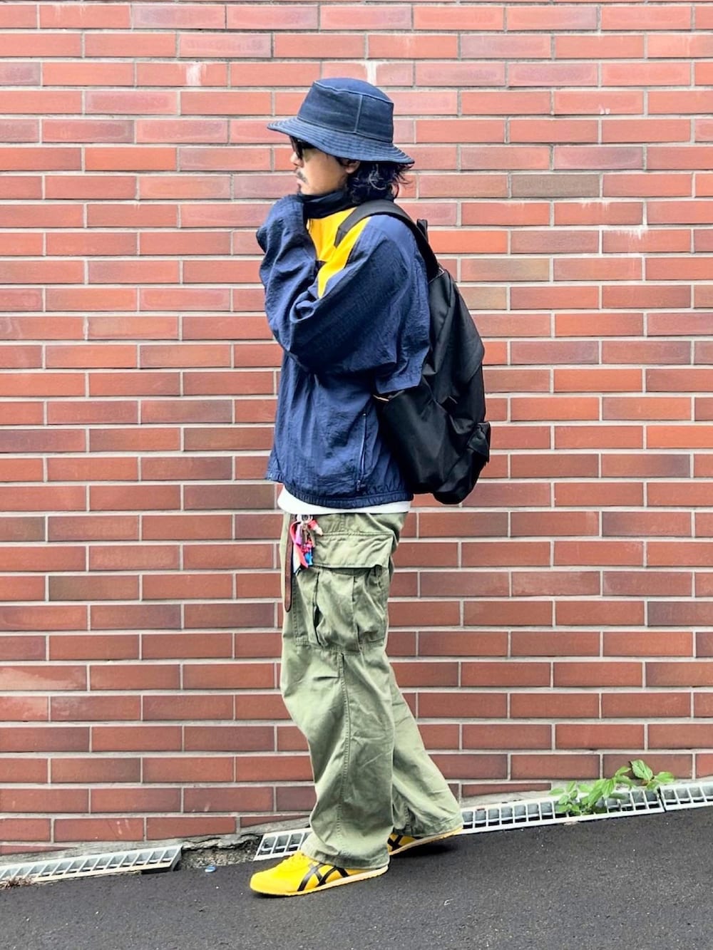 ホワイト系のTシャツ/カットソー、イエロー系のスニーカー、ブルー系のナイロンジャケットを着用したメンズの秋コーディネートの2枚目の写真