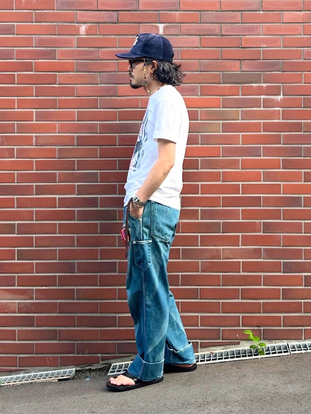 グレー系のタンクトップ、ブラック系のサンダル、ホワイト系のTシャツ/カットソーを着用したメンズの夏コーディネートの2枚目の写真