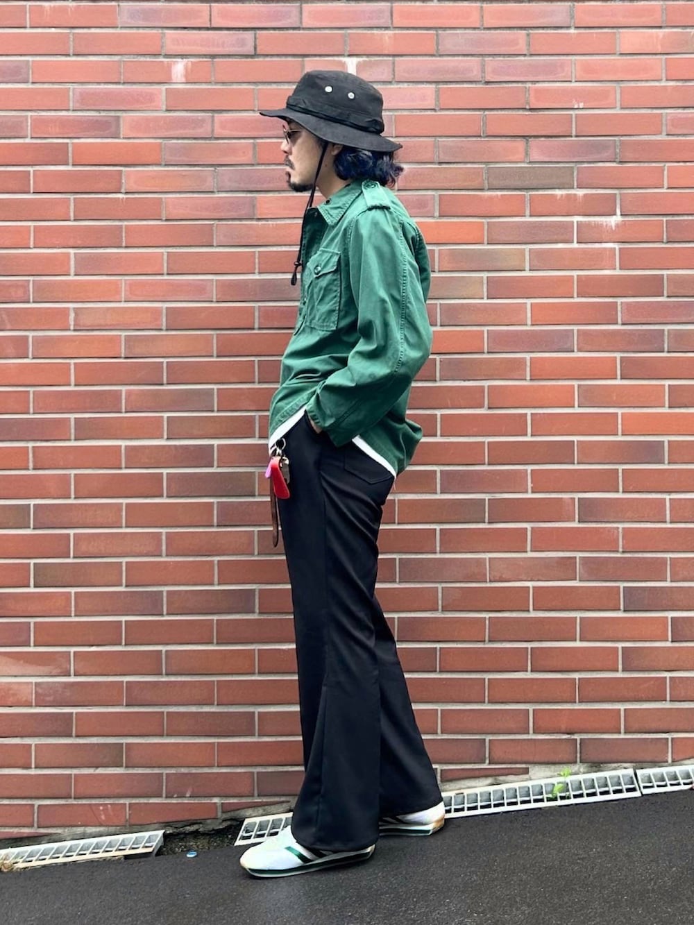 ブラック系のスラックス、ホワイト系のスニーカー、ホワイト系のTシャツ/カットソーを着用したメンズの秋コーディネートの2枚目の写真