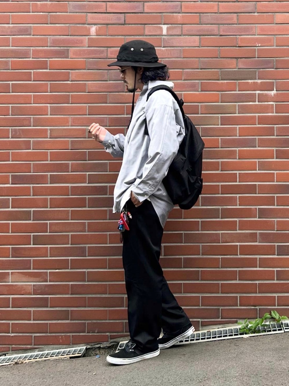 ブラック系のスニーカー、グレー系のシャツ/ブラウス、ホワイト系のTシャツ/カットソーを着用したメンズの秋コーディネートの2枚目の写真