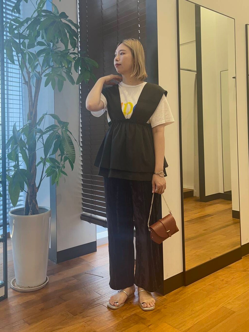 ブラウン系のショルダーバッグ、ブラック系のベスト、ブルー系のその他パンツを着用したレディースの夏コーディネートの2枚目の写真