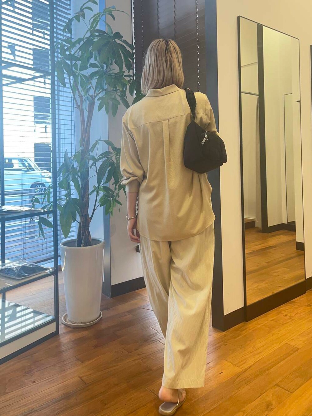 ベージュ系のその他パンツ、ベージュ系のシャツ/ブラウス、ブラック系のショルダーバッグを着用したレディースの夏コーディネートの2枚目の写真