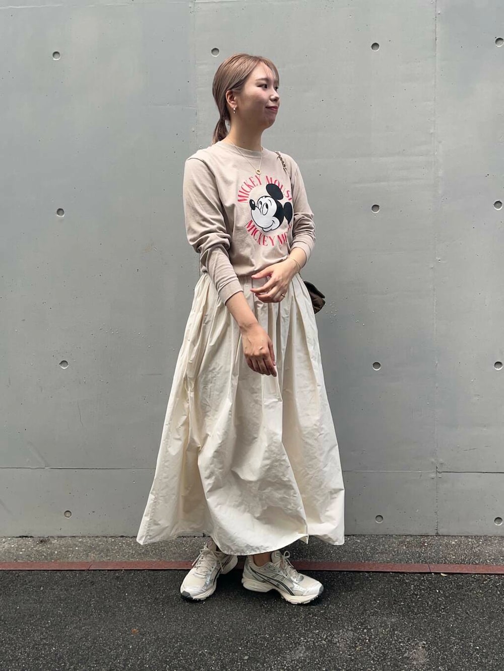 ブラウン系のショルダーバッグ、ホワイト系のスカート、ベージュ系のTシャツ/カットソーを着用したレディースの秋コーディネートの2枚目の写真