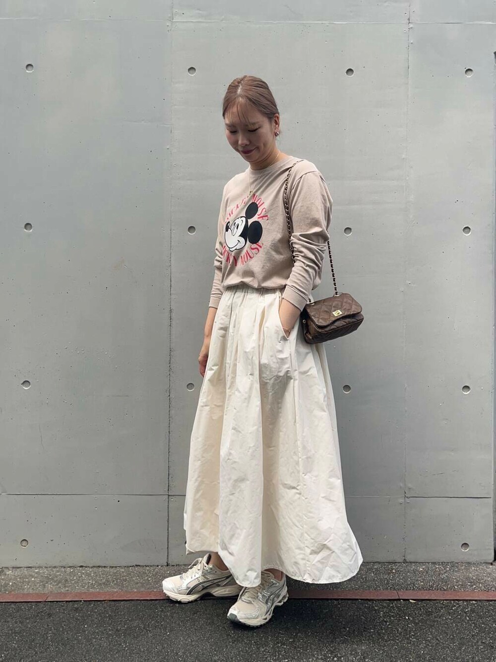 ブラウン系のショルダーバッグ、ホワイト系のスカート、ベージュ系のTシャツ/カットソーを着用したレディースの秋コーディネートの4枚目の写真