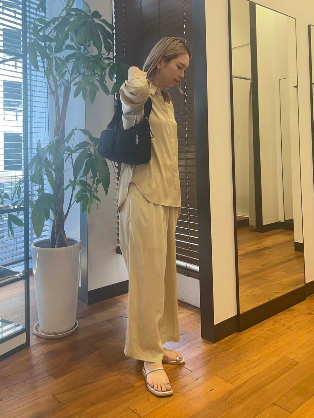 ベージュ系のその他パンツ、ベージュ系のシャツ/ブラウス、ブラック系のショルダーバッグを着用したレディースの夏コーディネートの3枚目の写真