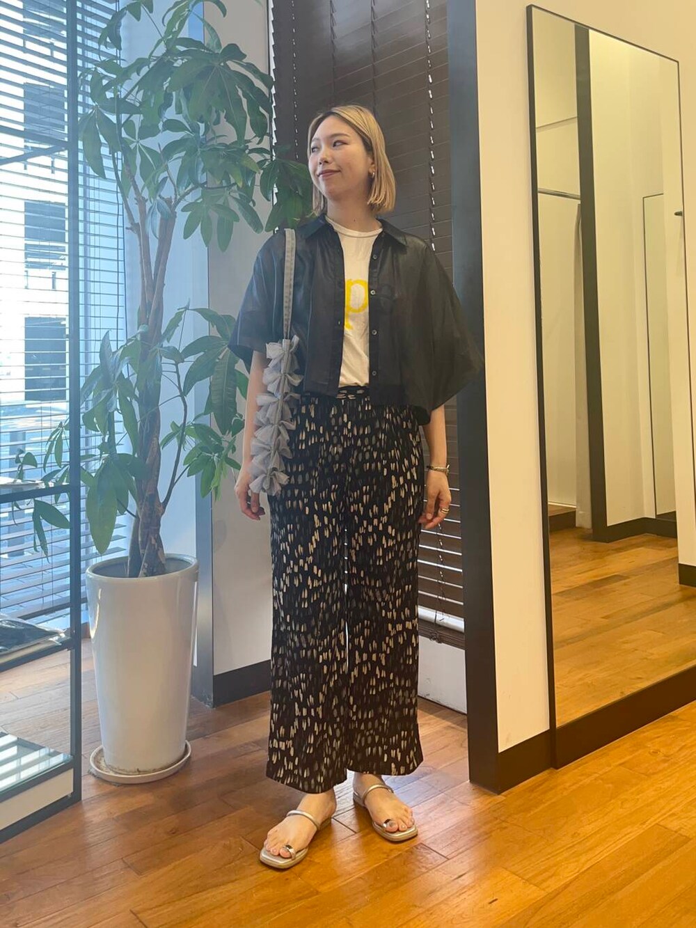 グレー系のトートバッグ、ブルー系のシャツ/ブラウス、ブラック系のその他パンツを着用したレディースの夏コーディネートの3枚目の写真