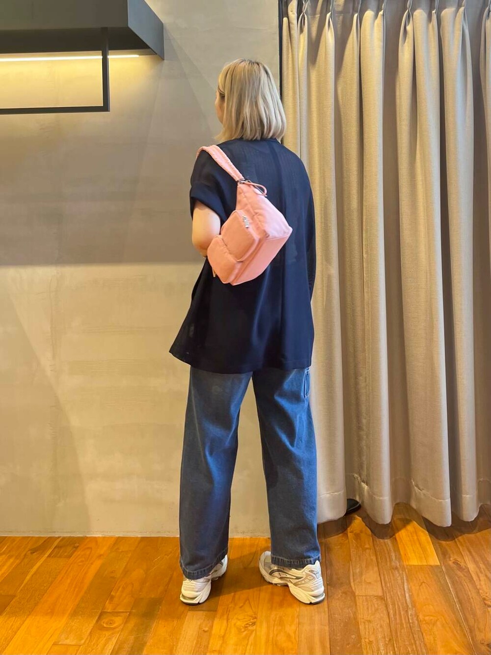 ブルー系のデニムパンツ、ブルー系のテーラードジャケット、レッド系のショルダーバッグを着用したレディースの夏コーディネートの4枚目の写真