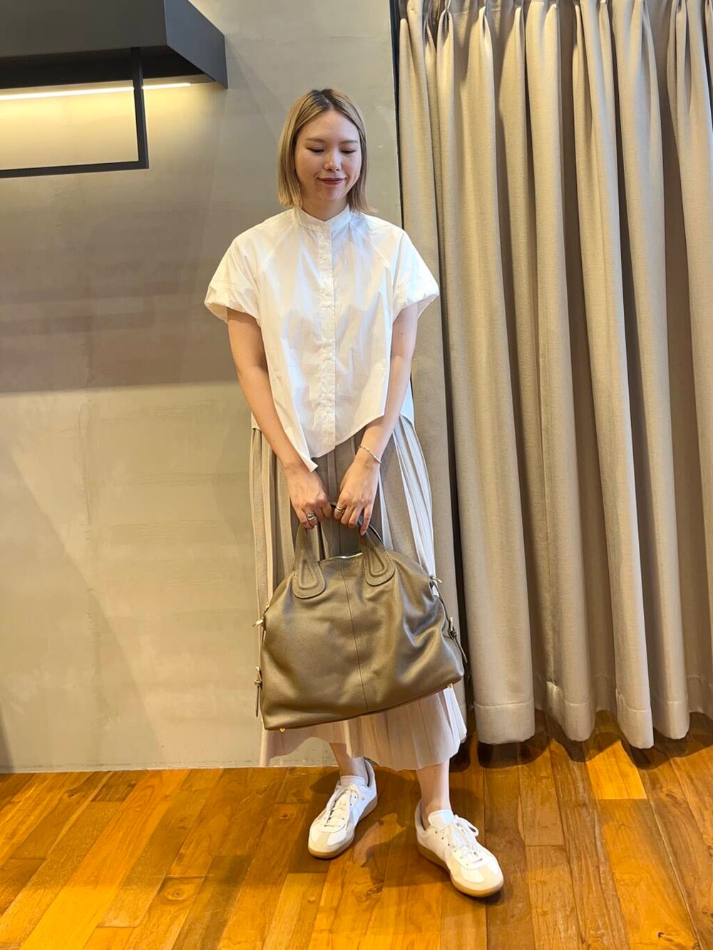 ホワイト系のシャツ/ブラウス、ブラウン系のスカート、ベージュ系のボストンバッグを着用したレディースの夏コーディネートの2枚目の写真