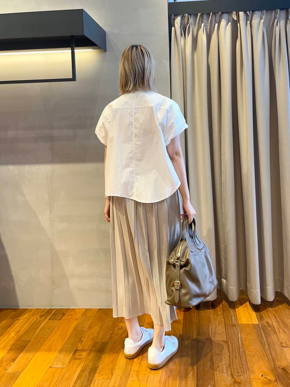 ホワイト系のシャツ/ブラウス、ブラウン系のスカート、ベージュ系のボストンバッグを着用したレディースの夏コーディネートの3枚目の写真