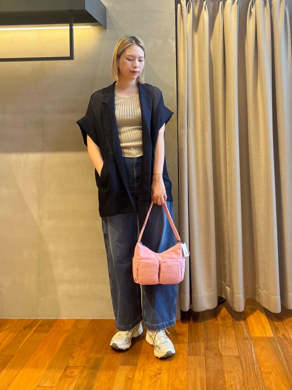 ブルー系のデニムパンツ、ブルー系のテーラードジャケット、レッド系のショルダーバッグを着用したレディースの夏コーディネートの3枚目の写真