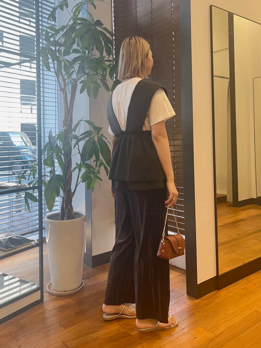 ブラウン系のショルダーバッグ、ブラック系のベスト、ブルー系のその他パンツを着用したレディースの夏コーディネートの3枚目の写真