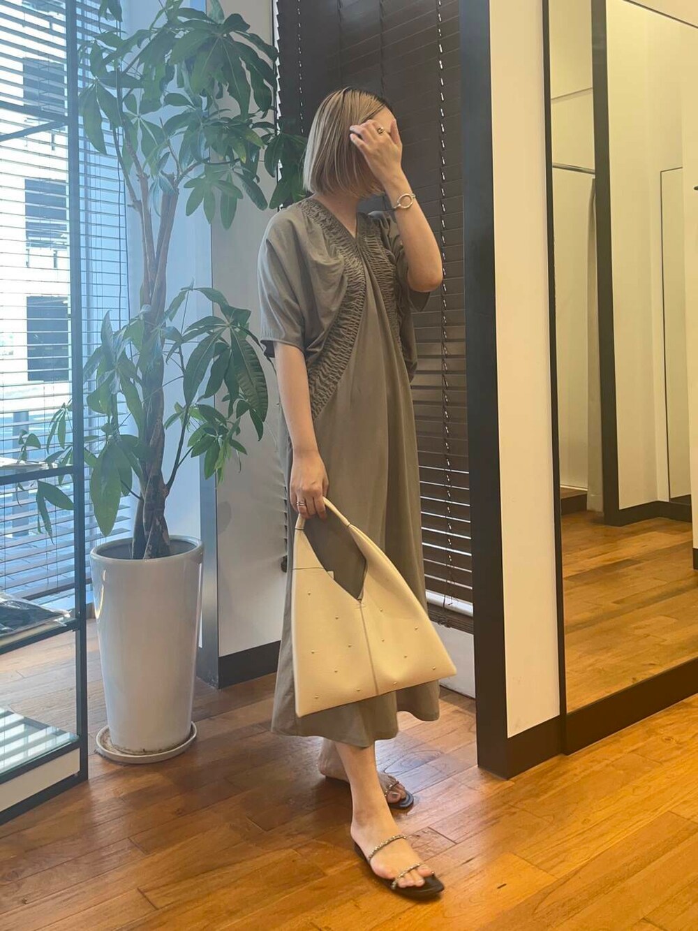 ブラック系のサンダル、ホワイト系のトートバッグ、グレー系のワンピースを着用したレディースの夏コーディネートの2枚目の写真