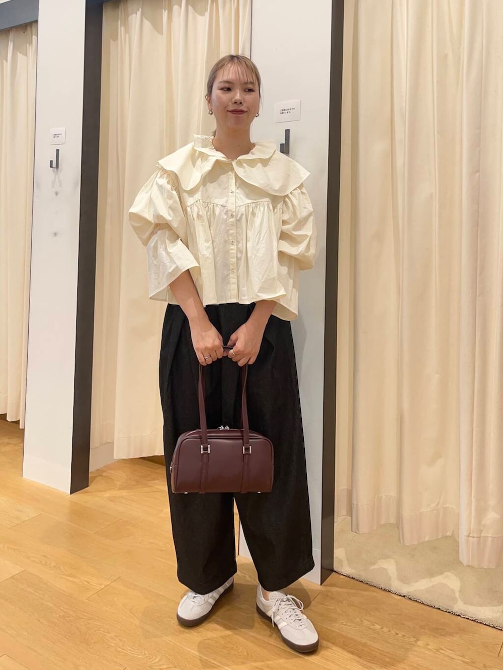 ブラック系のデニムパンツ、グレー系のスニーカー、ホワイト系のシャツ/ブラウスを着用したレディースの秋コーディネートの3枚目の写真