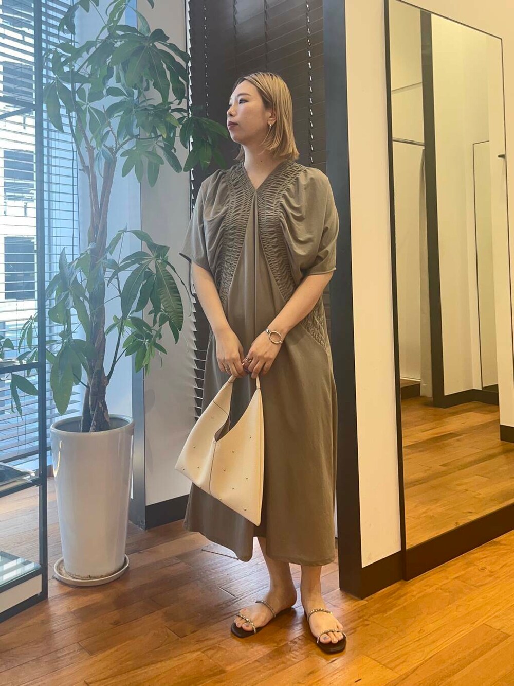 ブラック系のサンダル、ホワイト系のトートバッグ、グレー系のワンピースを着用したレディースの夏コーディネートの3枚目の写真