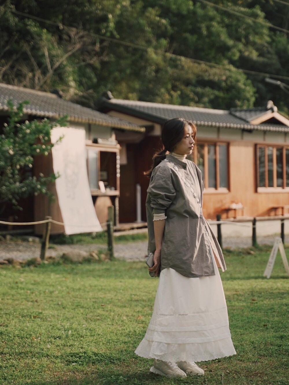 ブラウン系のシャツ/ブラウス、ホワイト系のスカート、ホワイト系のスニーカーを着用したレディースの秋コーディネートの4枚目の写真