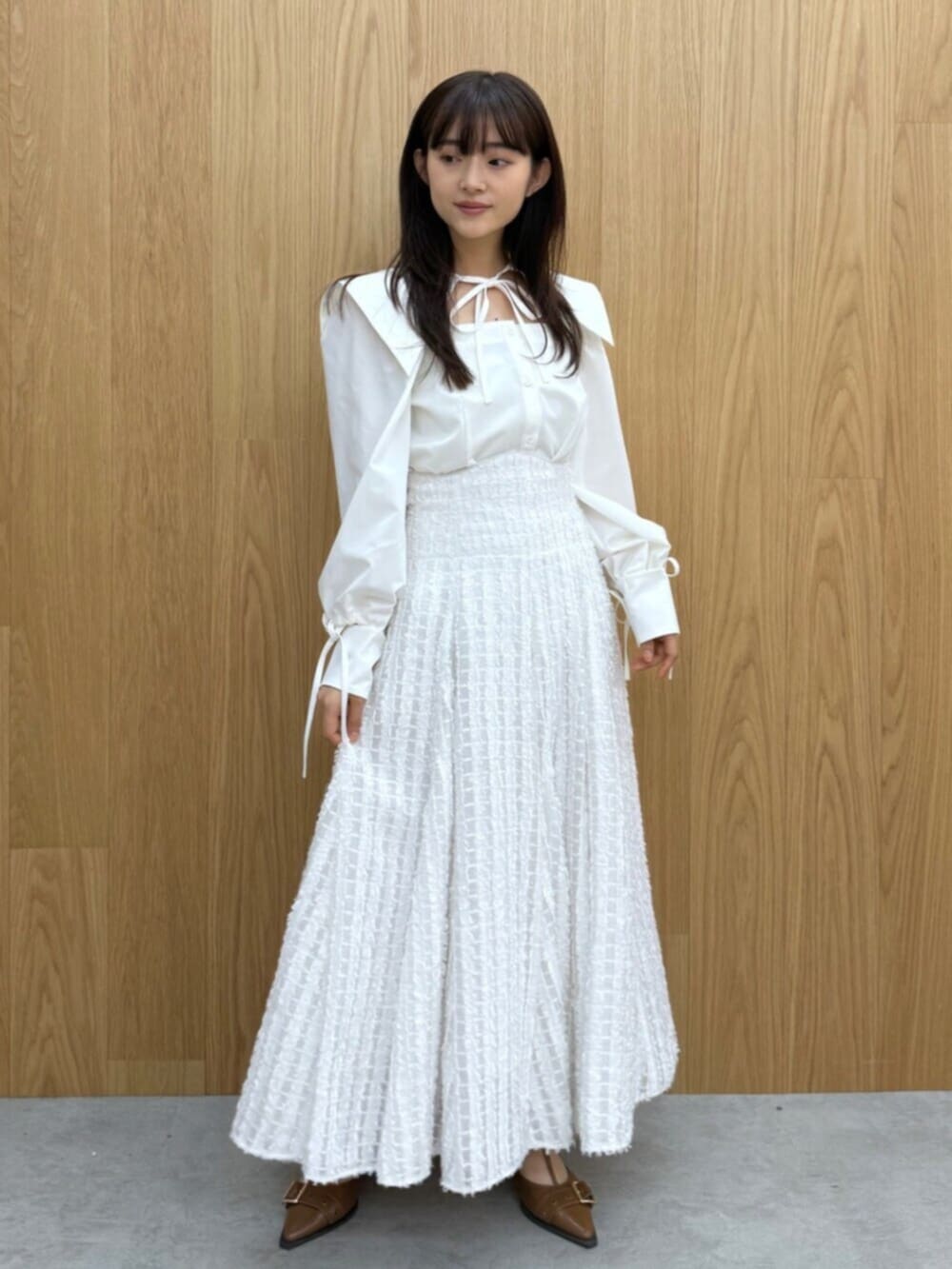 イエロー系のパンプス、ホワイト系のシャツ/ブラウス、ホワイト系のスカートを着用したレディースの夏コーディネートの3枚目の写真