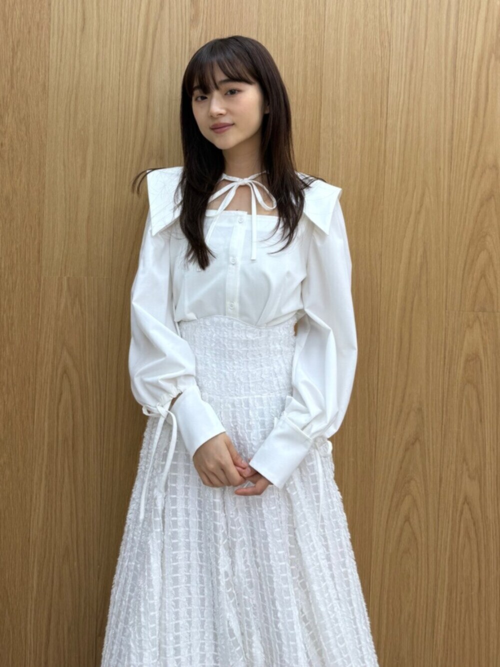 イエロー系のパンプス、ホワイト系のシャツ/ブラウス、ホワイト系のスカートを着用したレディースの夏コーディネートの2枚目の写真