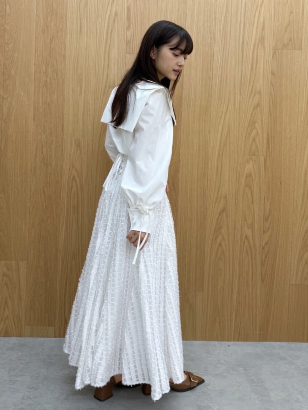 イエロー系のパンプス、ホワイト系のシャツ/ブラウス、ホワイト系のスカートを着用したレディースの夏コーディネートの4枚目の写真