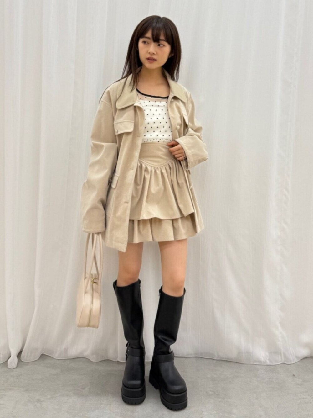 ホワイト系のTシャツ/カットソー、ブラック系のブーツ、ホワイト系のスカートを着用したレディースの夏コーディネートの2枚目の写真