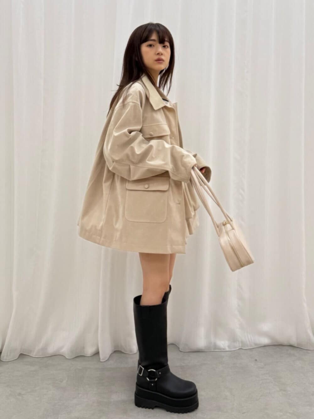 ホワイト系のTシャツ/カットソー、ブラック系のブーツ、ホワイト系のスカートを着用したレディースの夏コーディネートの3枚目の写真