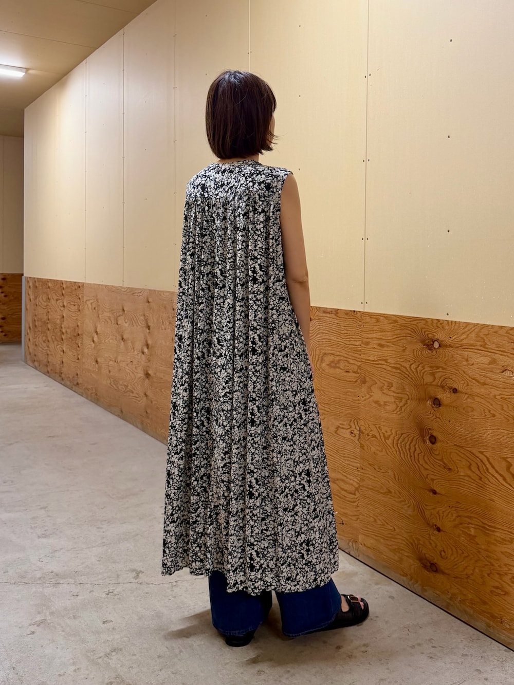 ブラック系のワンピース、ブルー系のデニムパンツ、ブラック系のサンダルを着用したレディースの夏コーディネートの5枚目の写真