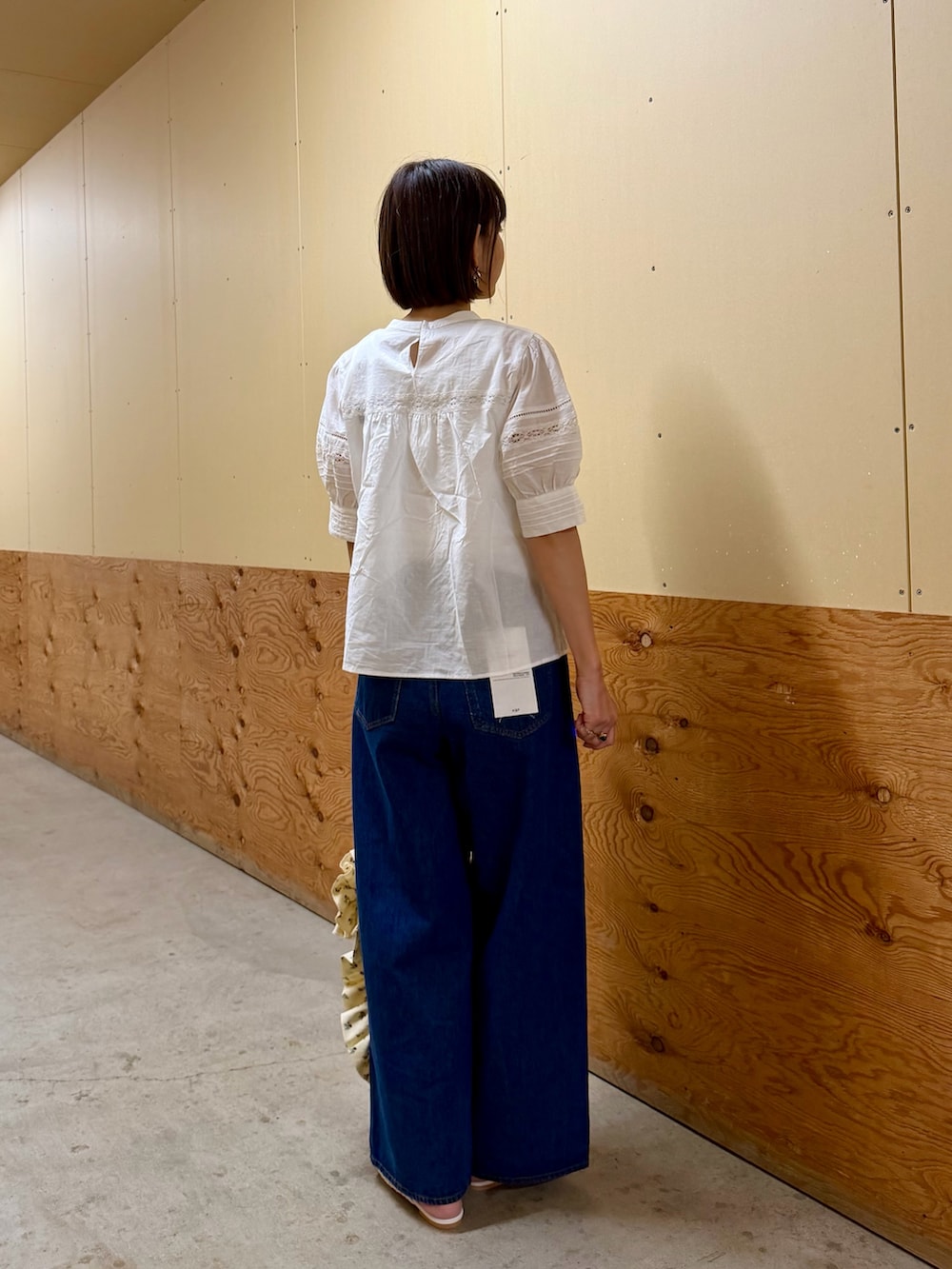 ブルー系のデニムパンツ、ホワイト系のトートバッグ、ホワイト系のサンダルを着用したレディースの夏コーディネートの6枚目の写真