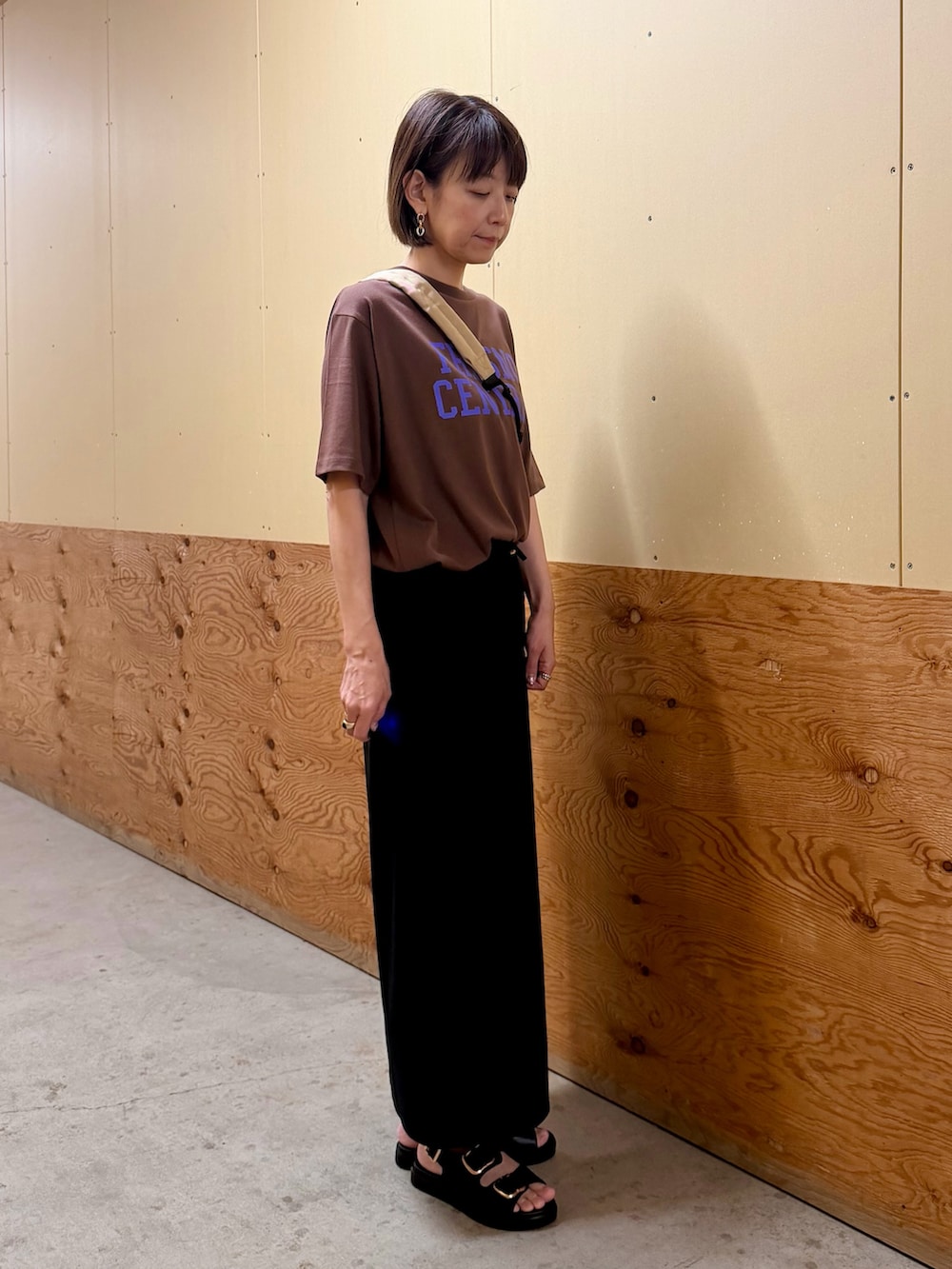 ブラック系のスカート、ブラック系のサンダル、ブラウン系のTシャツ/カットソーを着用したレディースの夏コーディネートの5枚目の写真