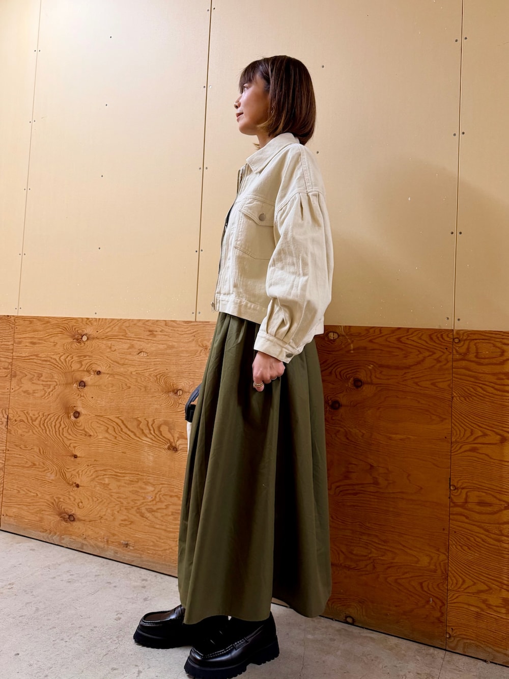 ホワイト系のブルゾン、ブラック系のシャツ/ブラウス、グリーン系のスカートを着用したレディースの冬コーディネートの3枚目の写真