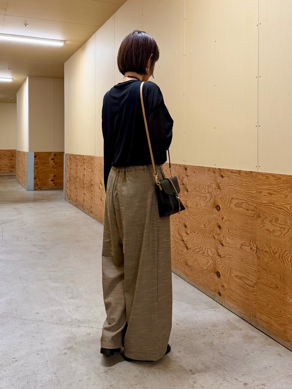 ブラック系のTシャツ/カットソー、ブラウン系のその他パンツ、ブラック系のショルダーバッグを着用したレディースの秋コーディネートの4枚目の写真