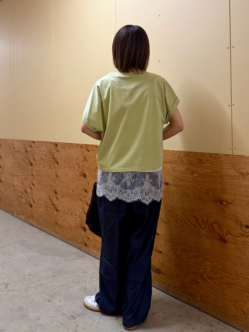 ブラウン系のTシャツ/カットソー、ベージュ系のキャミソール、ブルー系のデニムパンツを着用したレディースの春コーディネートの6枚目の写真