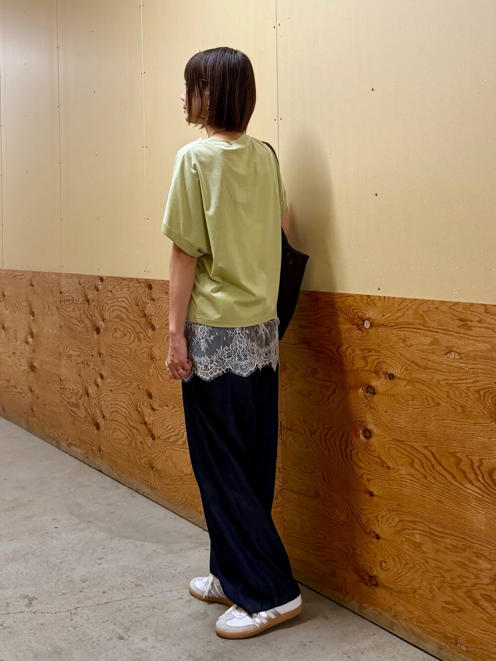 ブラウン系のTシャツ/カットソー、ベージュ系のキャミソール、ブルー系のデニムパンツを着用したレディースの春コーディネートの5枚目の写真
